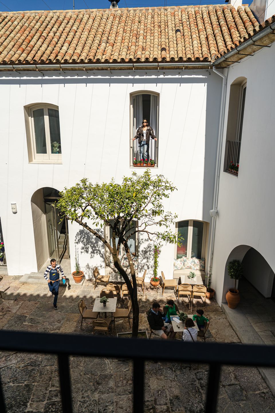 Patio encalado con un naranjo y arcos